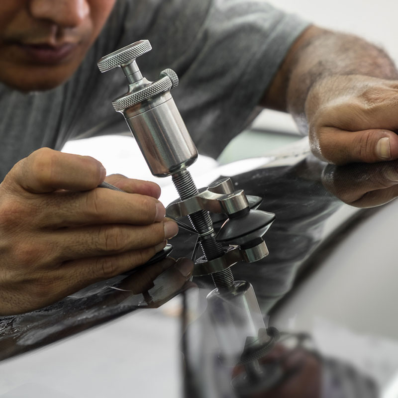 Technician repairing windshield chip